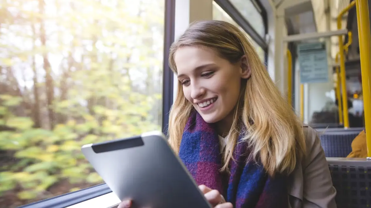 Person schaut eine heruntergeladene Serie auf dem Tablet in der Bahn